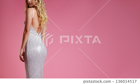 Back view woman in sequin dress, elegant backless gown against pink studio backdrop, blonde hair cascading, poised shoulder glance, fashion fitting atmosphere, shimmering texture and tailored Back view woman in sequin dress, elegant backless gown against pink studio backdrop, blonde hair cascading, poised shoulder glance, fashion fitting atmosphere, shimmering texture and tailored 136014517