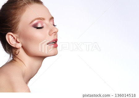 Closeup woman face with glitter eyeshadow and dewy makeup, soft studio lighting, gold hoop earring, hair swept back, serene expression, beauty commercial mood, smooth skin texture Closeup woman face with glitter eyeshadow and dewy makeup, soft studio lighting, gold hoop earring, hair swept back, serene expression, beauty commercial mood, smooth skin texture 136014518