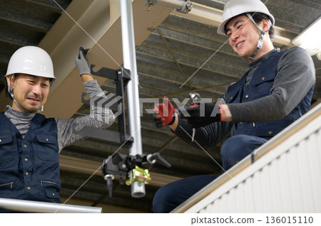 A man doing construction work in the attic 136015110