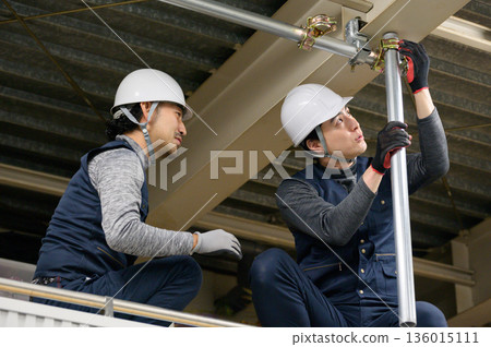 一名男子正在閣樓進行建築工作 一名男子正在閣樓進行建築工作 136015111