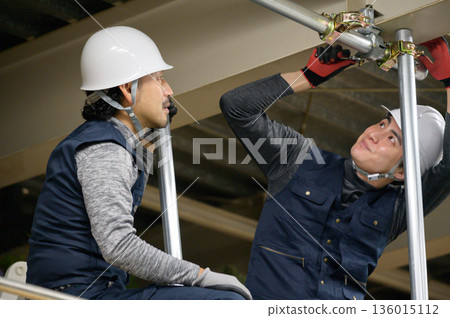 一名男子正在閣樓進行建築工作 一名男子正在閣樓進行建築工作 136015112