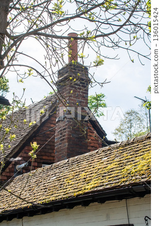 A historic red brick building with moss on the roof at Eastcote House in the suburbs of London A historic red brick building with moss on the roof at Eastcote House in the suburbs of London 136015424
