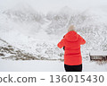 Person Standing in Snowy Mountains During Winter Fog. 136015430