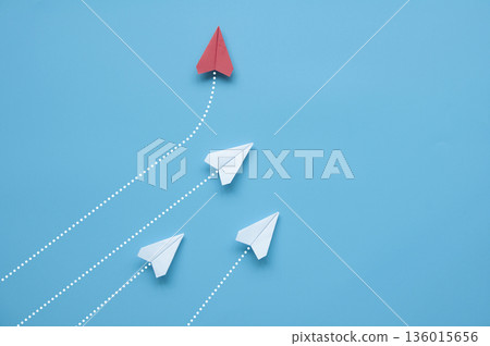 Paper airplane leaving motion trail on blue background symbolizing speed progress and decisive action. Paper airplane leaving motion trail on blue background symbolizing speed progress and decisive action. 136015656