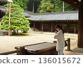 Senior woman praying at a shrine 136015672