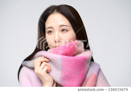 A smiling woman wearing a scarf on a white background 136015674