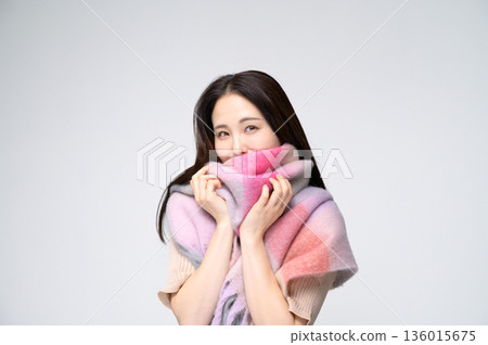 A smiling woman wearing a scarf on a white background 136015675