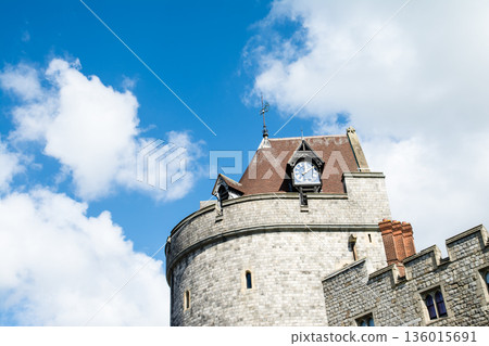 Historic stone Windsor Castle under a bright blue sky and floating clouds, a London suburban streetscape 136015691