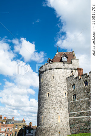 Historic stone Windsor Castle under a bright blue sky and floating clouds, a London suburban streetscape 136015708