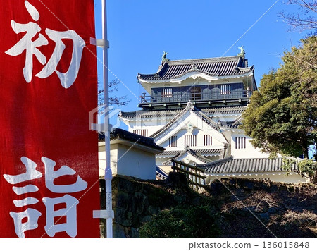 仰望岡崎城的主塔，在藍天和新年第一次參拜神社的旗幟的映襯下熠熠生輝（岡崎城公園，愛知縣岡崎市） 136015848