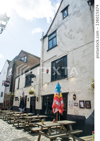 在倫敦郊區溫莎一條鵝卵石街道上，商店前擺放著桌椅。 136015874