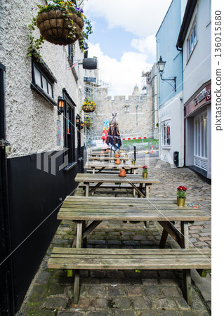 Tables and chairs lined up in front of shops on a cobblestone street in Windsor, a suburb of London 136015880