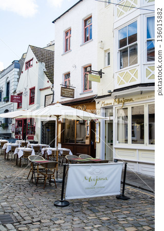 在倫敦郊區溫莎一條鵝卵石街道上，商店前擺放著桌椅。 136015882