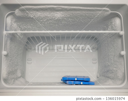 Frosted Freezer Interior with Ice Packs and Heavy Ice Buildup 136015974