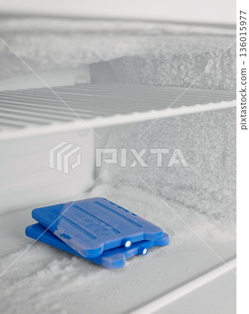 Icy Freezer Shelf with Ice Packs and Frost Buildup 136015977
