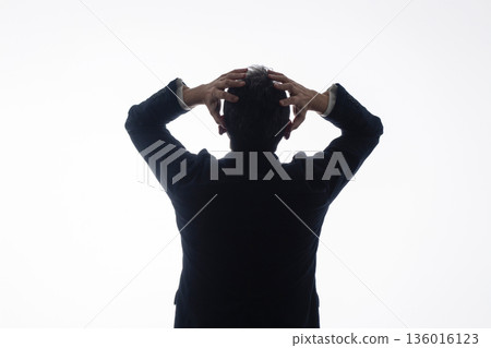 Silhouette of a worried businessman Silhouette of a worried businessman 136016123