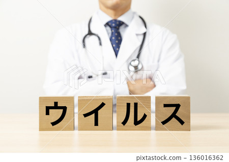 一塊寫著「病毒」字樣的磚塊和一個醫生 136016362