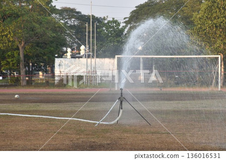 sprinkler injecting and splashing water to watering football or soccer grass field in summer sprinkler injecting and splashing water to watering football or soccer grass field in summer 136016531