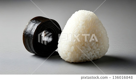 Still life, Monochrome minimalist. a stark composition a single, dark piece of pickled seaweed (kombu) curl placed beside a perfectly shaped white rice ball  136016848