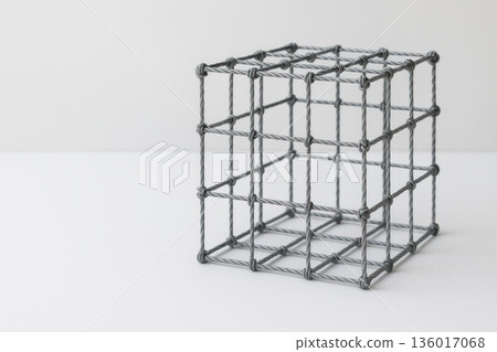 Metal cubic frame made of intertwined wire. Space for text. 136017068