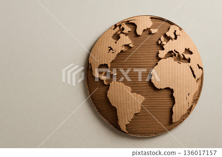 Cardboard globe with continents cut out on a light background. Space for text. Cardboard globe with continents cut out on a light background. Space for text. 136017157