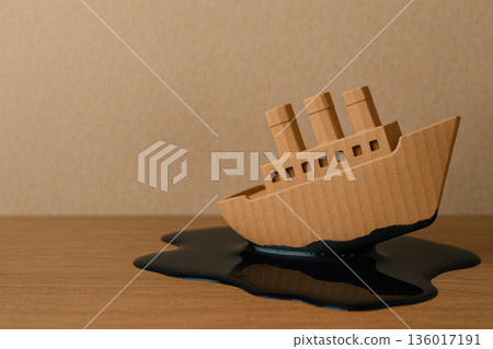 A cardboard ship sinks in the black liquid of oil. Space for text. 136017191