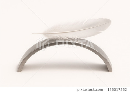 A white feather lying on a curved metal object. A white feather lying on a curved metal object. 136017262