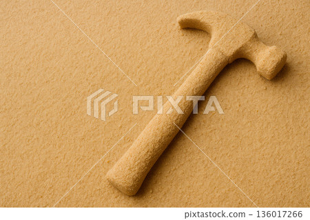 A sand hammer on a sandy background is the concept of the fragility of tools. Space for text. A sand hammer on a sandy background is the concept of the fragility of tools. Space for text. 136017266