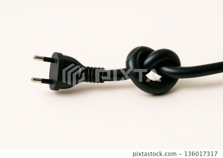 A black electric plug with a knot on the wire. A black electric plug with a knot on the wire. 136017317