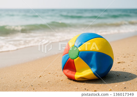An inflated beach ball lies on a sandy beach. An inflated beach ball lies on a sandy beach. 136017349