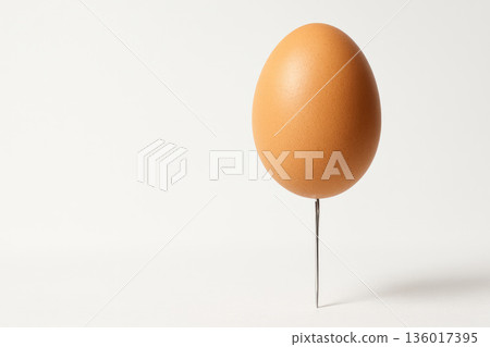 An egg on a sharp nail. Space for text. 136017395