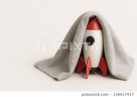 The rocket hides under the covers from fear of launch. Space for text. The rocket hides under the covers from fear of launch. Space for text. 136017437
