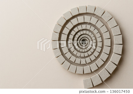 Spiral of stone squares on a light background. Space for text. Spiral of stone squares on a light background. Space for text. 136017450