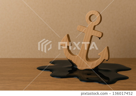 A wooden anchor is immersed in a black liquid. Space for text. A wooden anchor is immersed in a black liquid. Space for text. 136017452