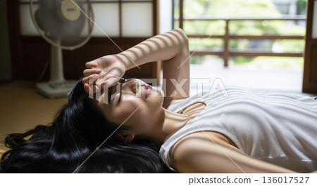 一位日本女子躺在榻榻米房間休息。 一位日本女子躺在榻榻米房間休息。 136017527