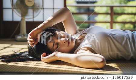 一位日本女子躺在榻榻米房間休息。 136017529