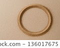 A circle of sand on a beige background. Space for text. 136017675