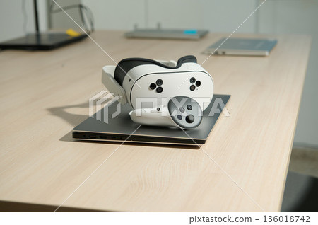 VR Headset Resting On Laptop On Wooden Desk In Modern Office Setting VR Headset Resting On Laptop On Wooden Desk In Modern Office Setting 136018742