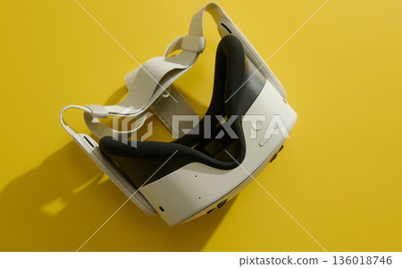 Virtual Reality Headset On Bright Yellow Background For Immersive Tech Demonstration Virtual Reality Headset On Bright Yellow Background For Immersive Tech Demonstration 136018746