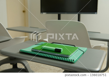 Classroom Desk With Green Notebooks And Marker In Front Of Presentation Screen 136018751