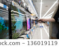 A woman's hand choosing a TV at a mass retailer 136019119