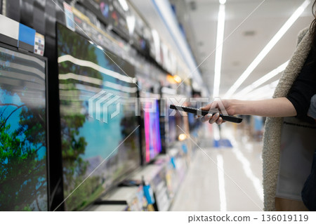 A woman's hand choosing a TV at a mass retailer 136019119