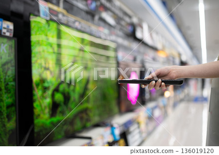 一位女士的手正在一家大型零售店挑選電視機 一位女士的手正在一家大型零售店挑選電視機 136019120