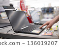 Woman's hand choosing a laptop in a store 136019207
