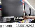 A woman's hand choosing a monitor at a mass retailer 136019208