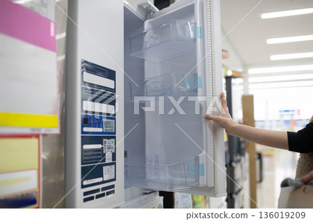 Woman's hand choosing a refrigerator at a mass retailer Woman's hand choosing a refrigerator at a mass retailer 136019209