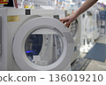 A woman's hand choosing a washing machine at a mass retailer 136019210