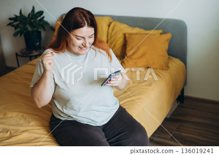 Happy woman holding mobile phone smartphone cellphone good news notification message rejoice celebrate. Female win achievement delighted lucky technology enjoy internet emotional joyful smiling Happy woman holding mobile phone smartphone cellphone good news notification message rejoice celebrate. Female win achievement delighted lucky technology enjoy internet emotional joyful smiling 136019241