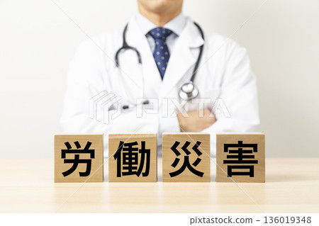 一塊寫著「工傷意外」的磚塊，旁邊站著一位醫生 136019348