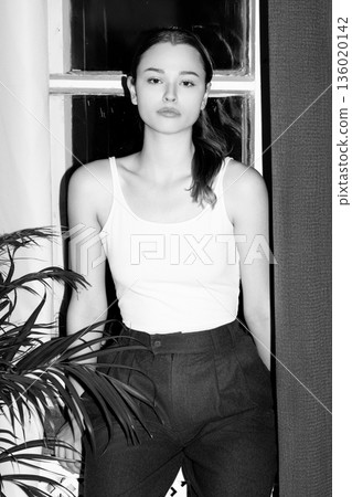 Young woman posing casually by window indoors 136020142
